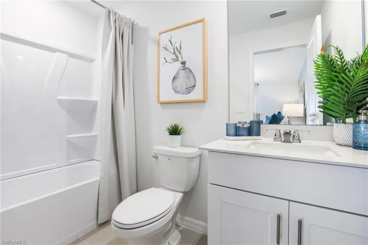 Bathroom featuring a white vanity with a light-colored countertop, an integrated sink, and brushed nickel hardware