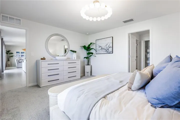 Spacious room featuring light gray carpeting and white walls