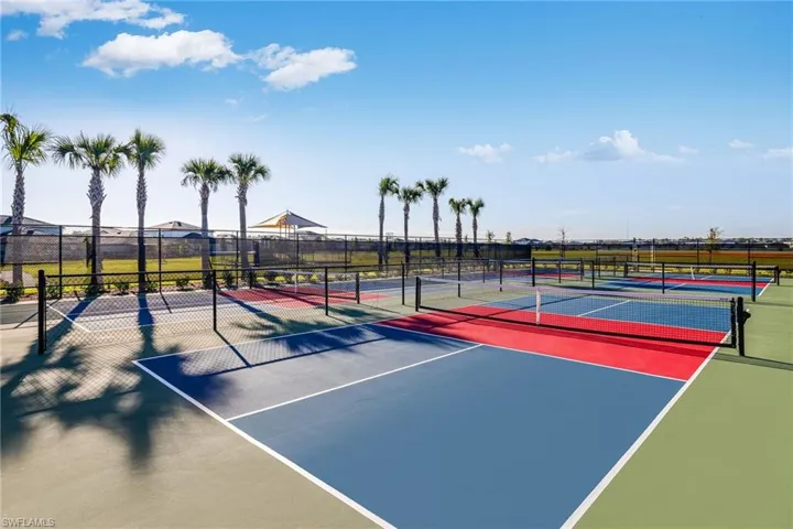 Multiple outdoor pickleball courts featuring blue, red, and green surfaces with white line markings