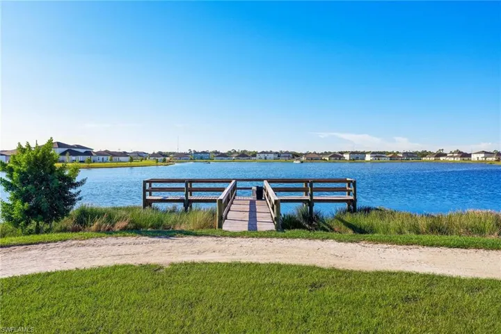 Waterfront property featuring a private wooden dock, expansive water frontage, and a clear blue sky