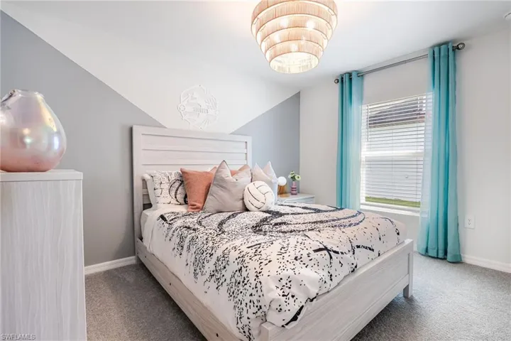 Bedroom featuring a single window with blinds, carpet flooring, base molding, and a drum-style ceiling light fixture
