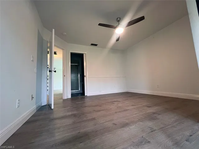 Spare room featuring a ceiling fan and dark wood finished floors