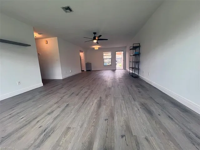 Unfurnished living room with ceiling fan and wood finished floors
