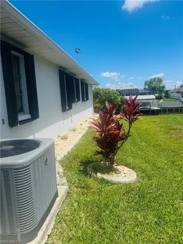 View of grassy yard with central air condition unit