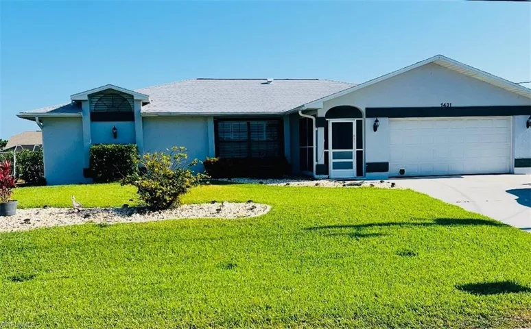 Single story home with an attached garage, a front yard, stucco siding, and driveway