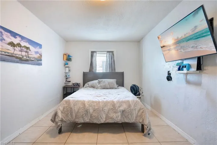 Bedroom with light tile patterned floors and a textured ceiling