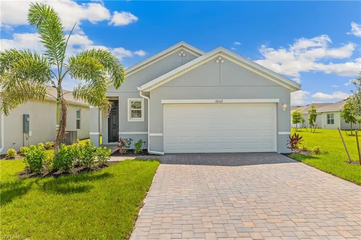 Single story home featuring decorative driveway, a front lawn, stucco siding, and a garage