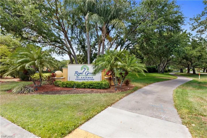 Community entry sign for Royal Green at Gateway Condominiums, featuring established landscaping, mature trees, and a winding paved pathway