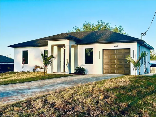 View of front of home with a shingled roof, driveway, stucco siding, and an attached garage