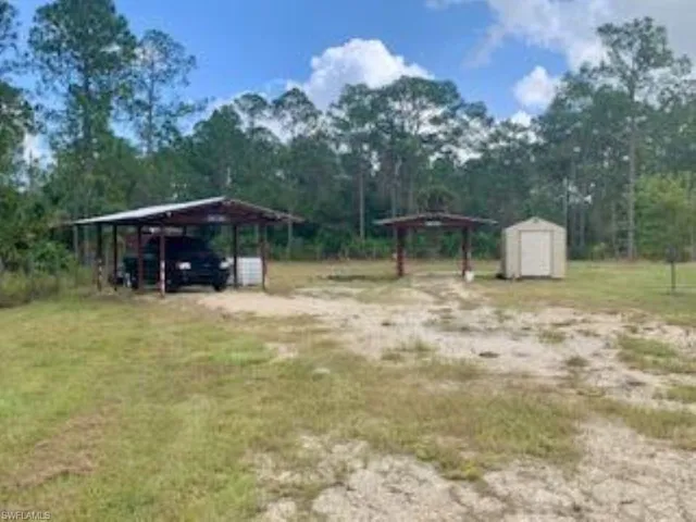 View of yard with a shed and a carport