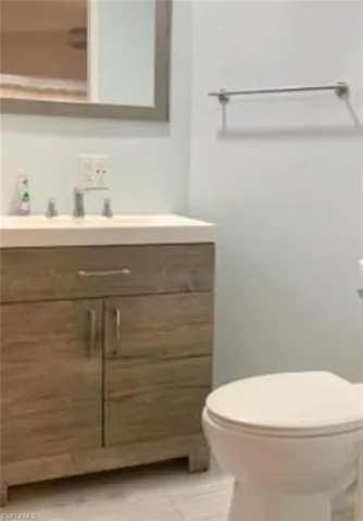 Bathroom with vanity, toilet, and tile patterned flooring