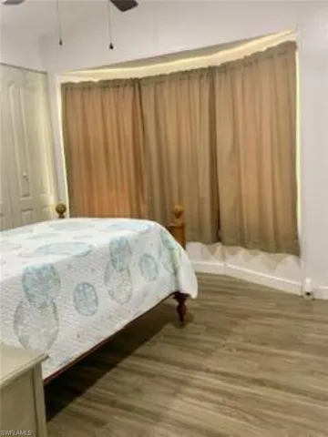 Bedroom featuring a closet, dark hardwood / wood-style floors, and ceiling fan