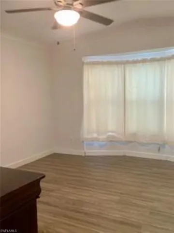 Empty room featuring ornamental molding, hardwood / wood-style floors, and ceiling fan