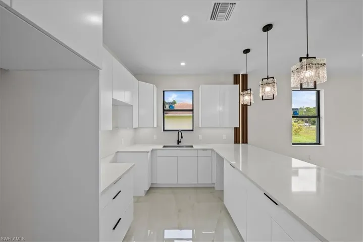 White cabinetry with undermount sink, solid surface countertops, and integrated lighting
