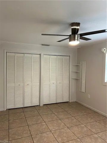 Unfurnished bedroom featuring tile patterned flooring, baseboards, and ceiling fan