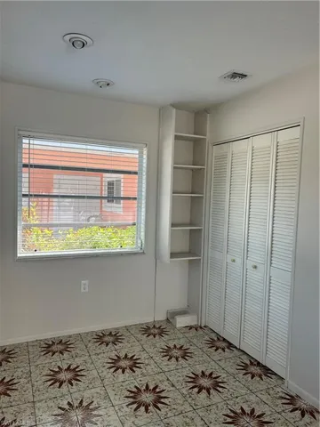 Unfurnished bedroom with a closet, visible vents, and baseboards