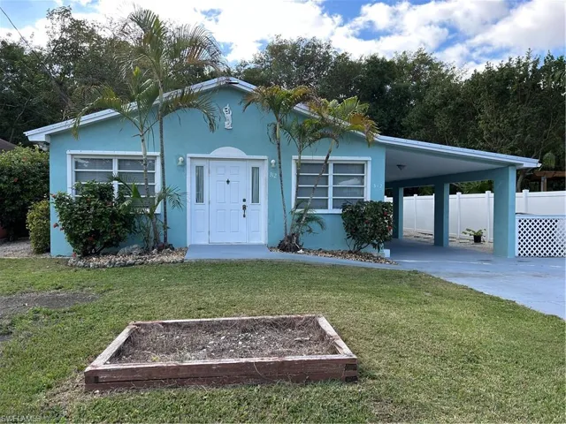 View of front of house with a front lawn and a carport