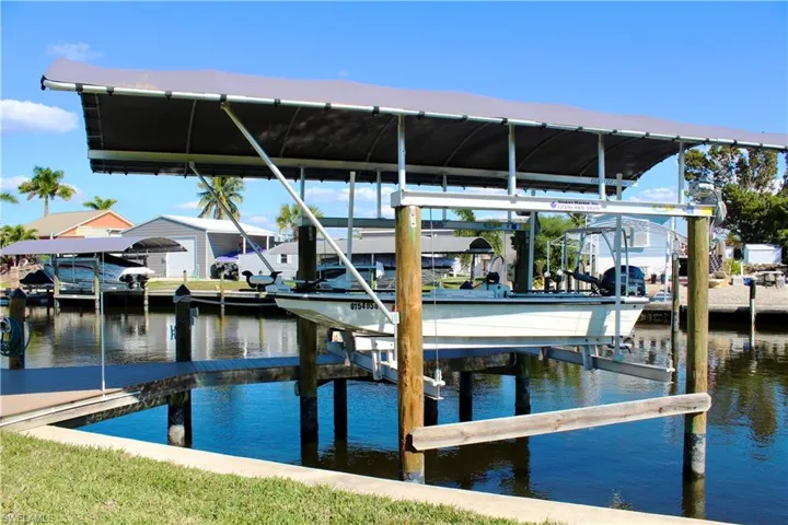 Dock area featuring boat lift and a water view