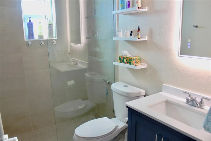 Full bath featuring vanity, a walk in shower, and textured walls..Gorgeous