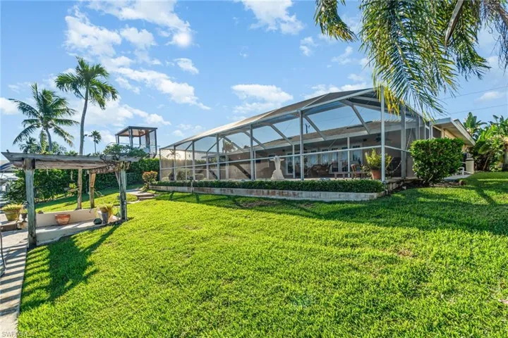 View of green lawn with glass enclosure, a sunroom, a patio area, and a pergola