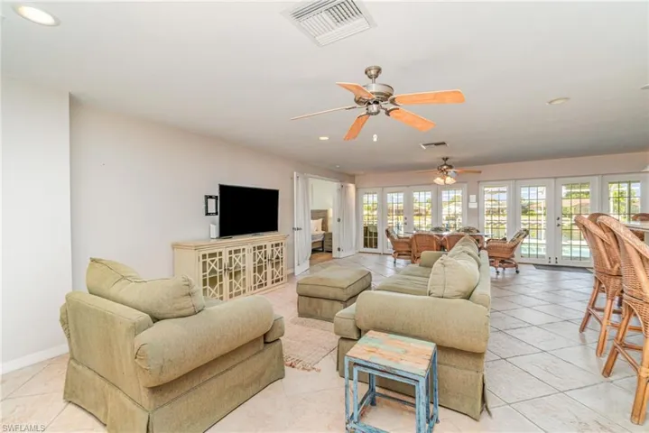 Living room with recessed lighting, ceiling fan, and tile patterned floors
