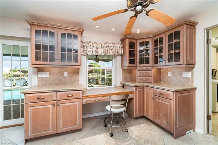 Office space with built in desk, recessed lighting, and a ceiling fan