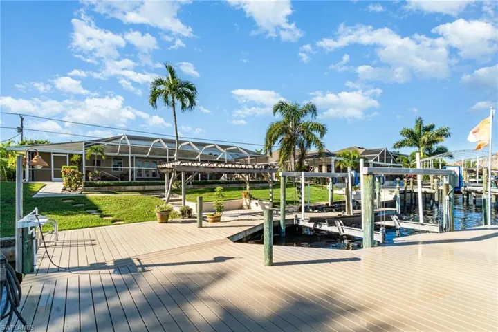 Dock area with boat lift and a lawn