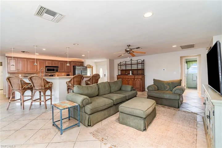 Living room featuring recessed lighting, light tile patterned flooring, and ceiling fan