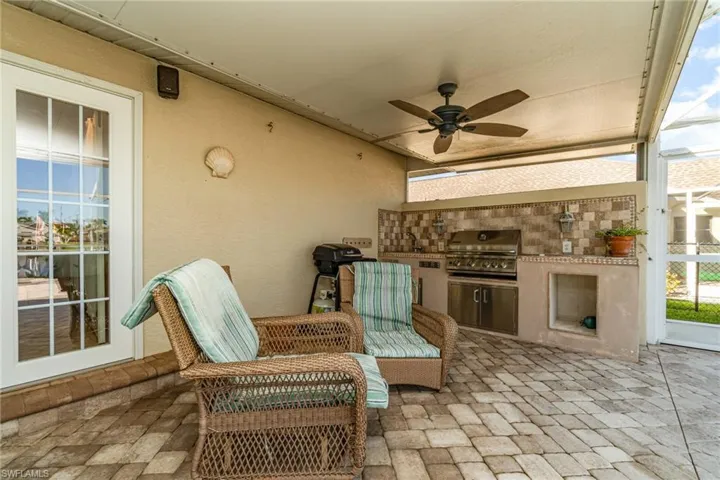 View of patio with a ceiling fan and an outdoor kitchen