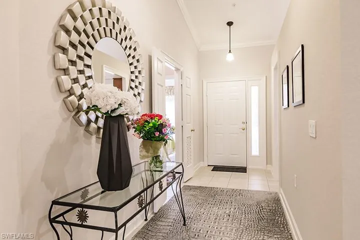 Tiled foyer featuring ornamental molding