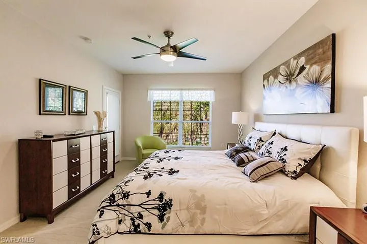 Carpeted bedroom featuring ceiling fan