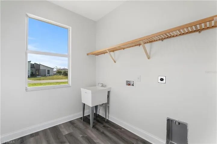 Laundry area with electric dryer hookup, washer hookup, dark wood finished floors, and baseboards