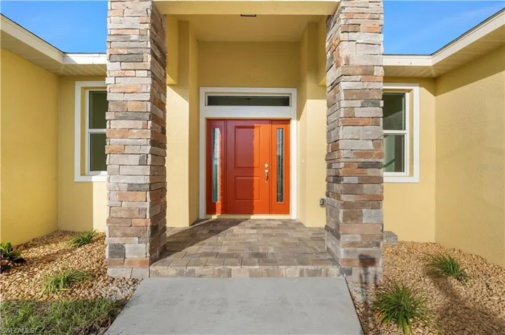 Doorway to property featuring stucco siding