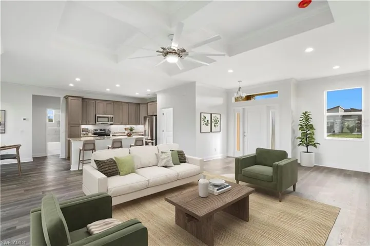 Living room with coffered ceiling, a ceiling fan, crown molding, recessed lighting, and baseboards