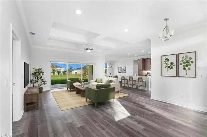 Living area with a chandelier, recessed lighting, ornamental molding, dark wood-style flooring, and beam ceiling