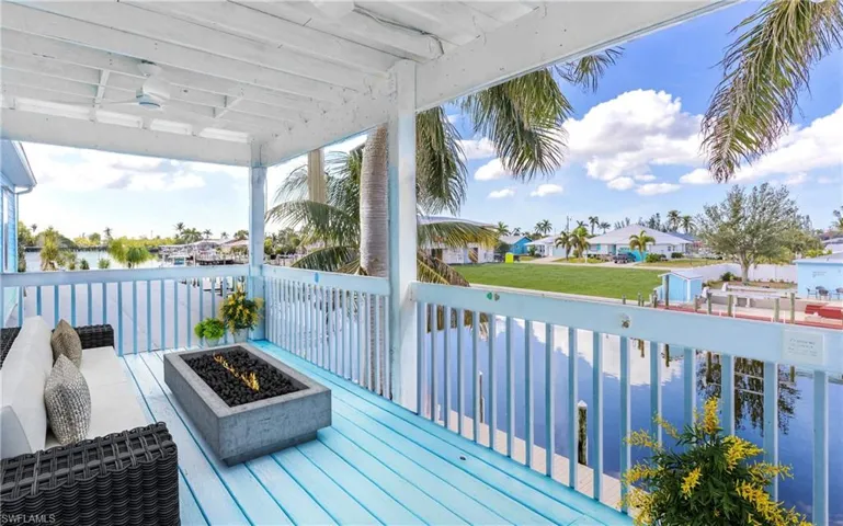 Wooden terrace with a fire pit, a residential view, and ceiling fan