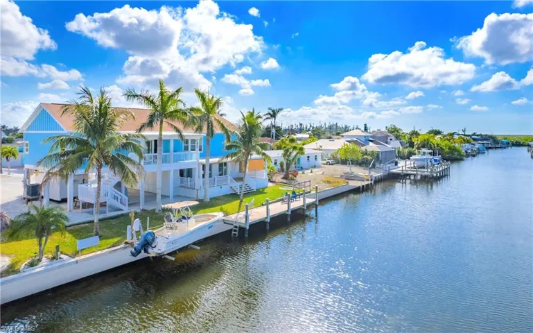 Dock with a water view, a balcony, a patio, boat lift, and a residential view