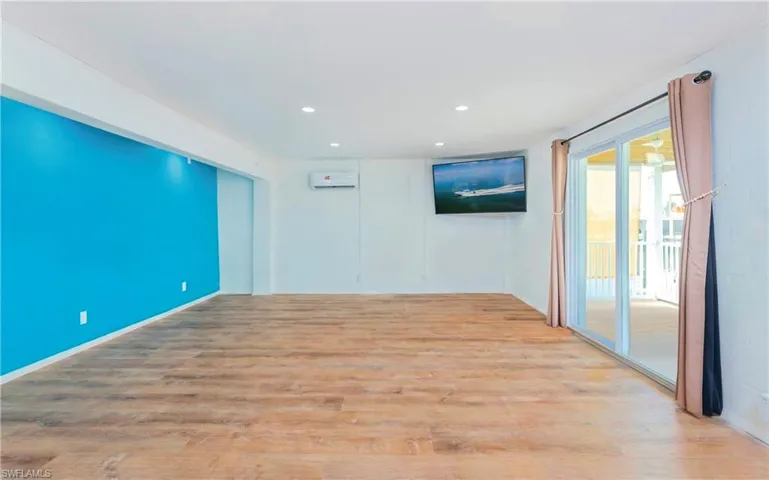 Spare room featuring light wood-style flooring, recessed lighting, and a wall mounted air conditioner