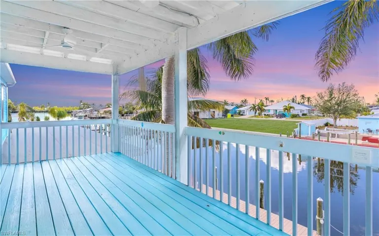 Deck at dusk featuring ceiling fan and a lawn