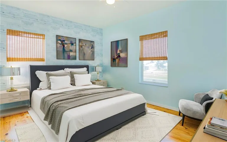 Bedroom featuring an accent wall, light wood-type flooring, and wallpapered walls