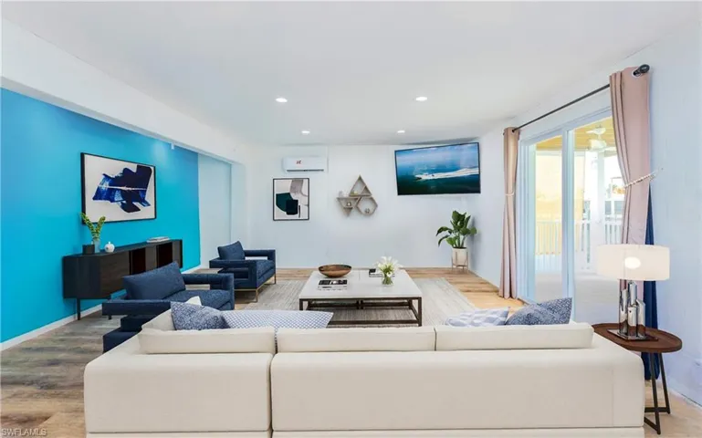 Living room featuring recessed lighting, wood finished floors, and a wall mounted AC