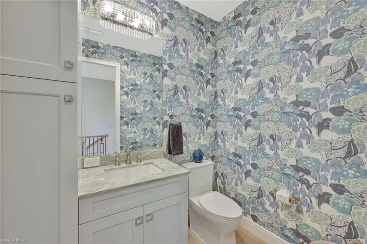 Powder room just off the great room with custom lighting and wallpaper.