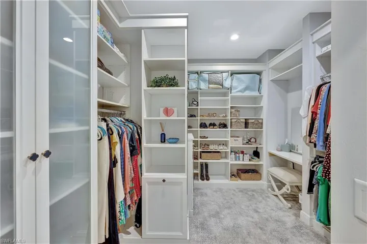 Primary closet with separate vanity area and PLENTY of room for shoes!