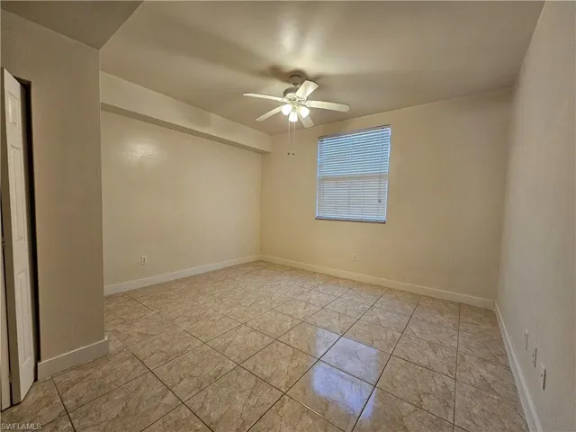 Spare room with a ceiling fan and baseboards