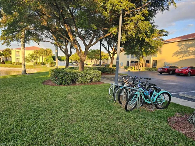 View of community with a yard and uncovered parking