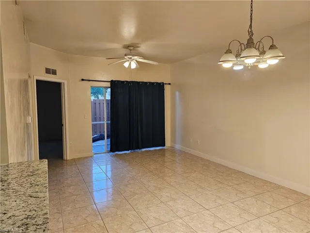 Unfurnished room featuring a ceiling fan and a chandelier