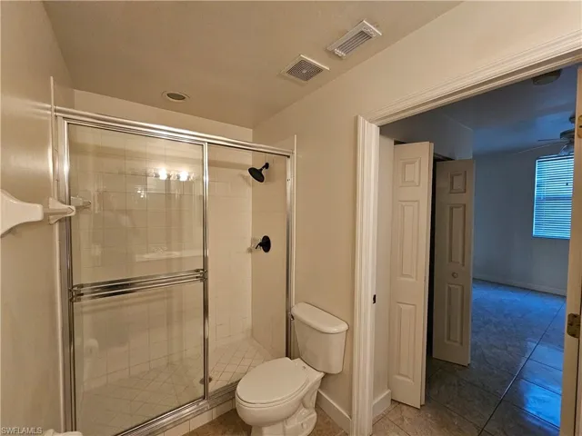Full bathroom with a stall shower and light tile patterned floors