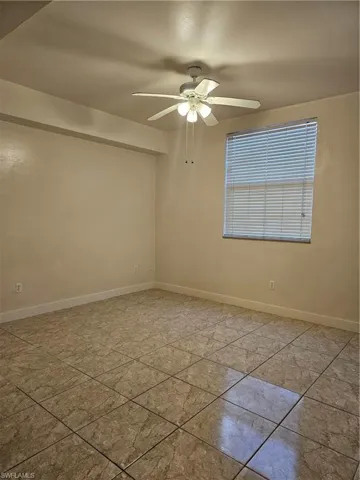 Unfurnished room featuring baseboards and ceiling fan