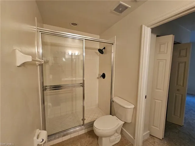 Full bathroom with a stall shower and light tile patterned flooring
