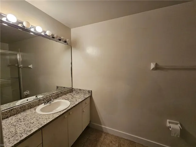 Bathroom featuring vanity, dark tile patterned floors, and a stall shower
